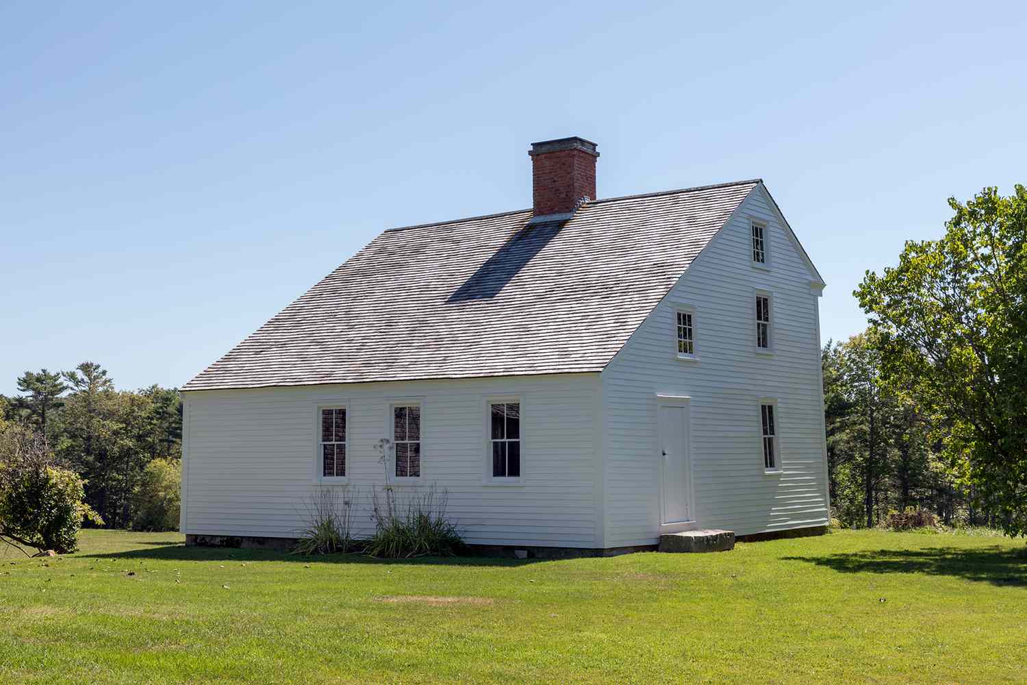 white saltbox house in green field