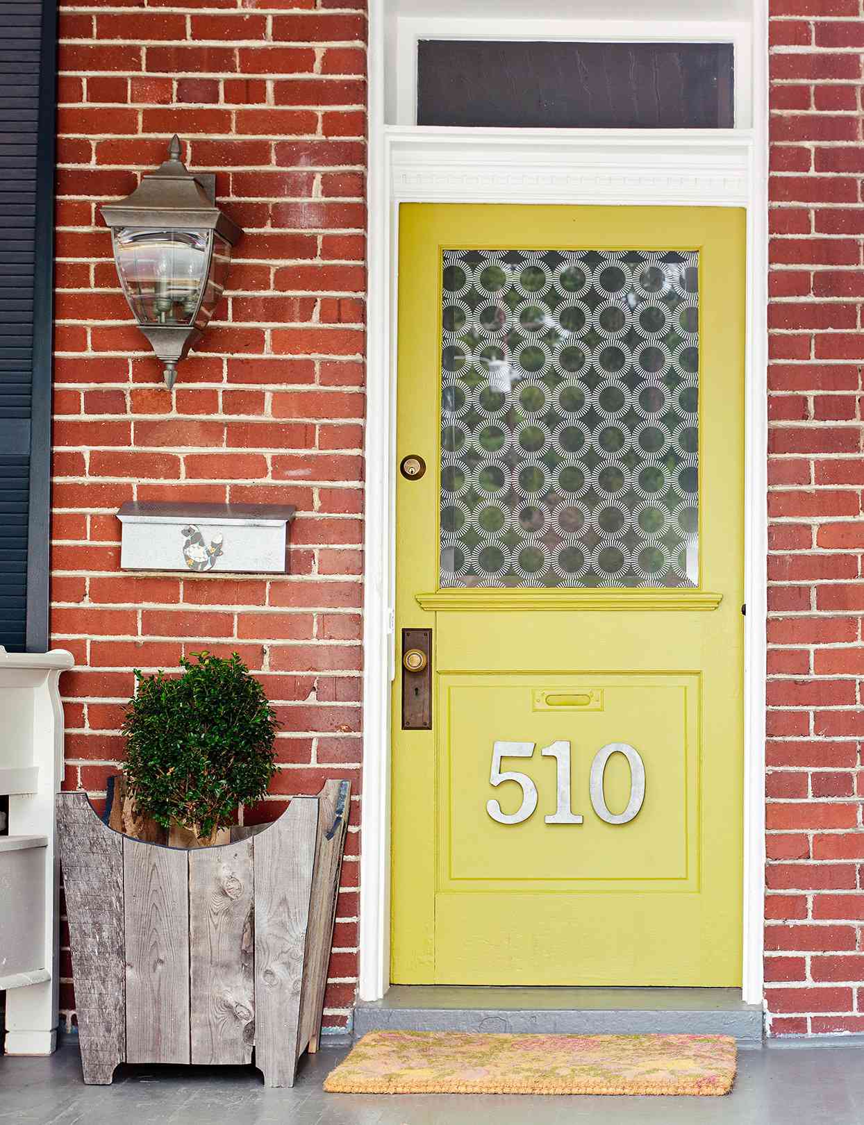 yellow-green front door with large numbered address