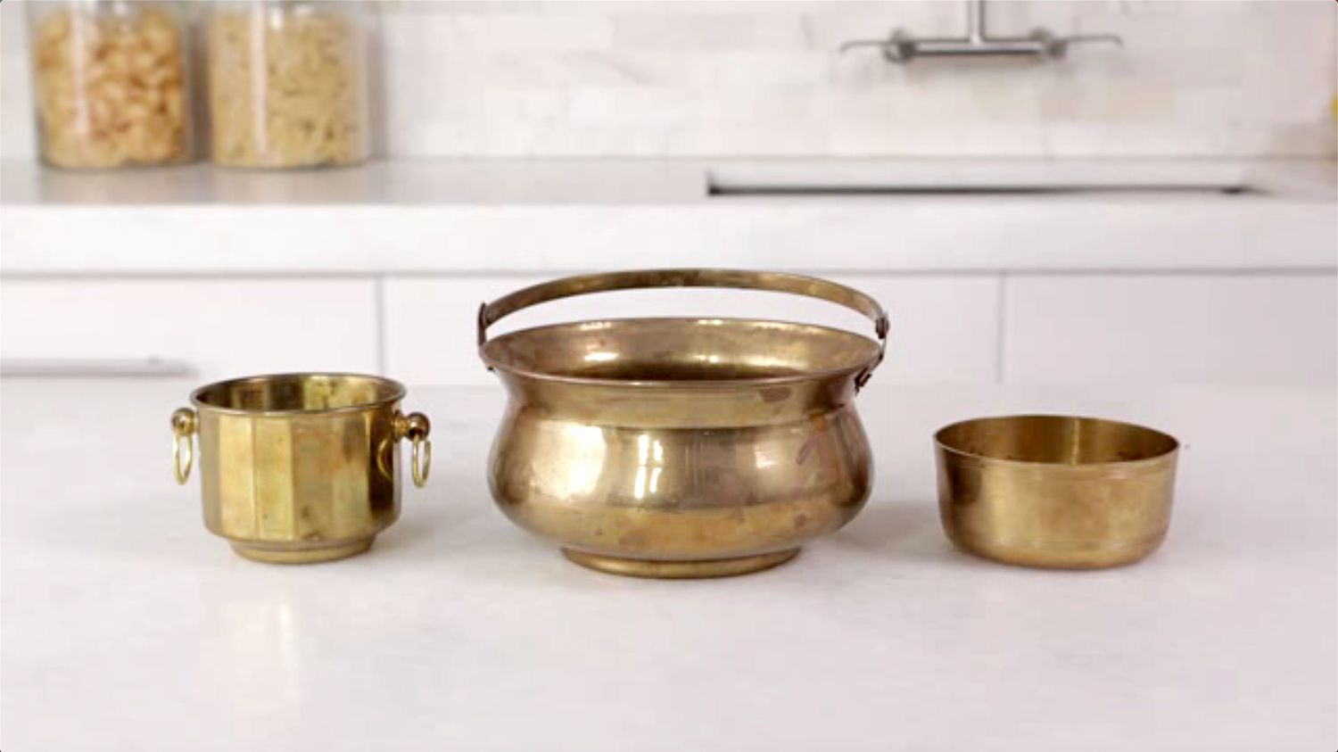 Three brass containers on counter