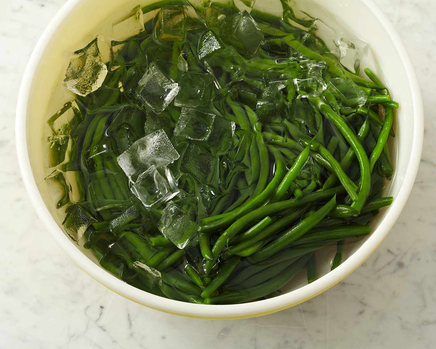 green beans in bowl of water with ice