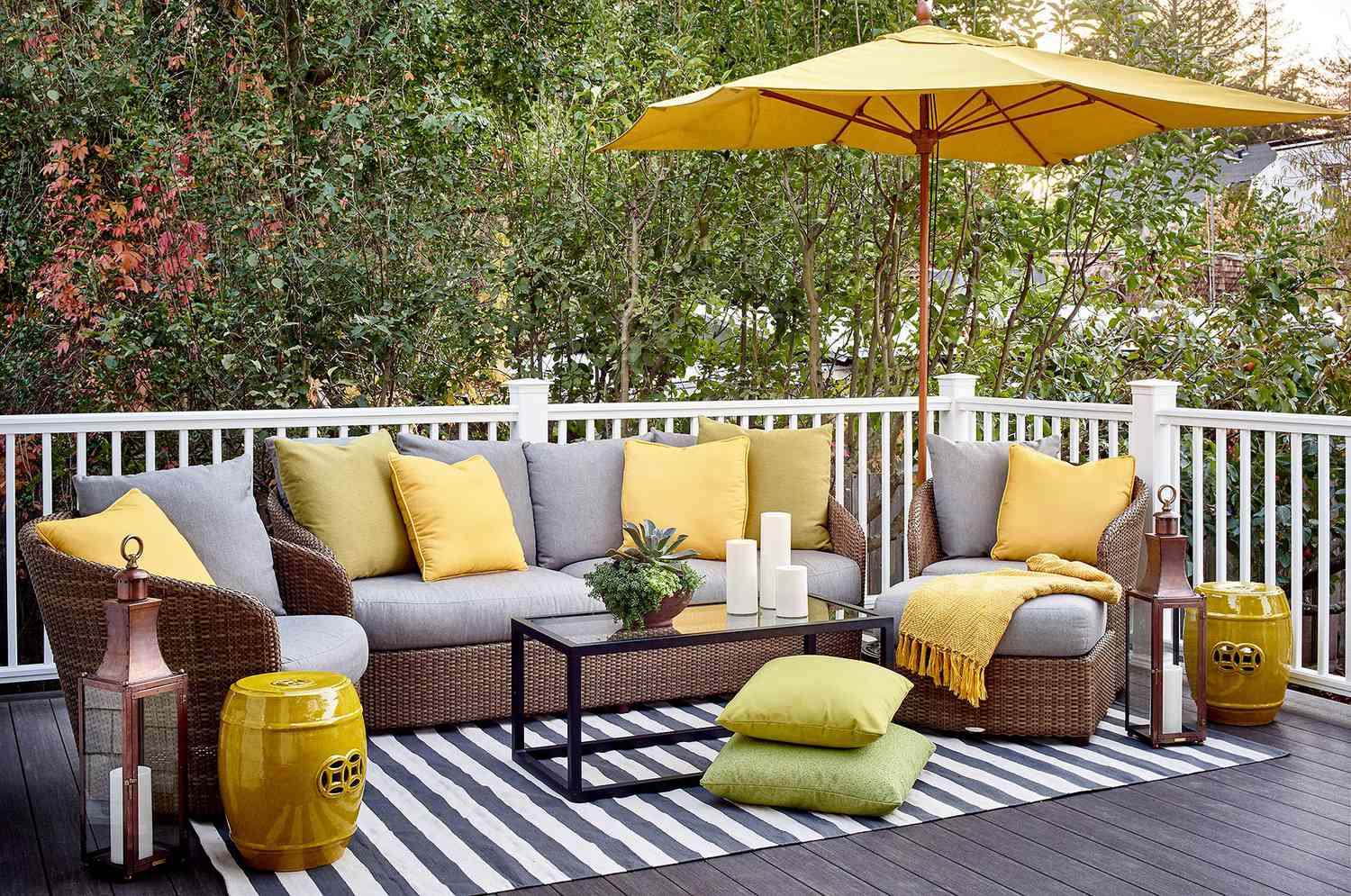 deck with woven patio furniture and gray and yellow cushions