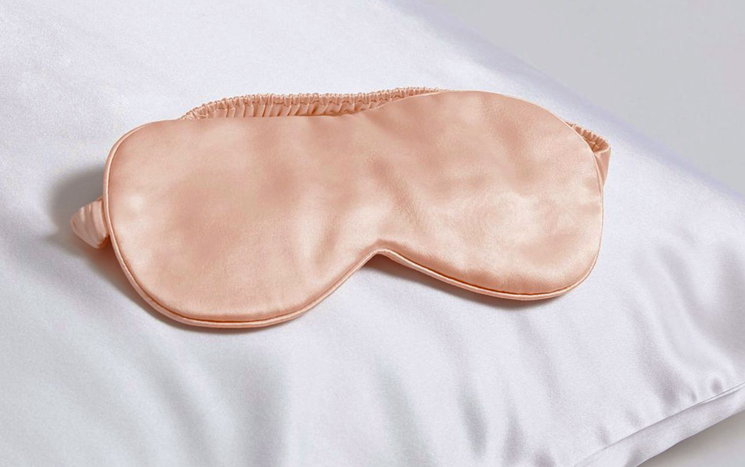 Brooklinen silk pink eyemask on a pillow