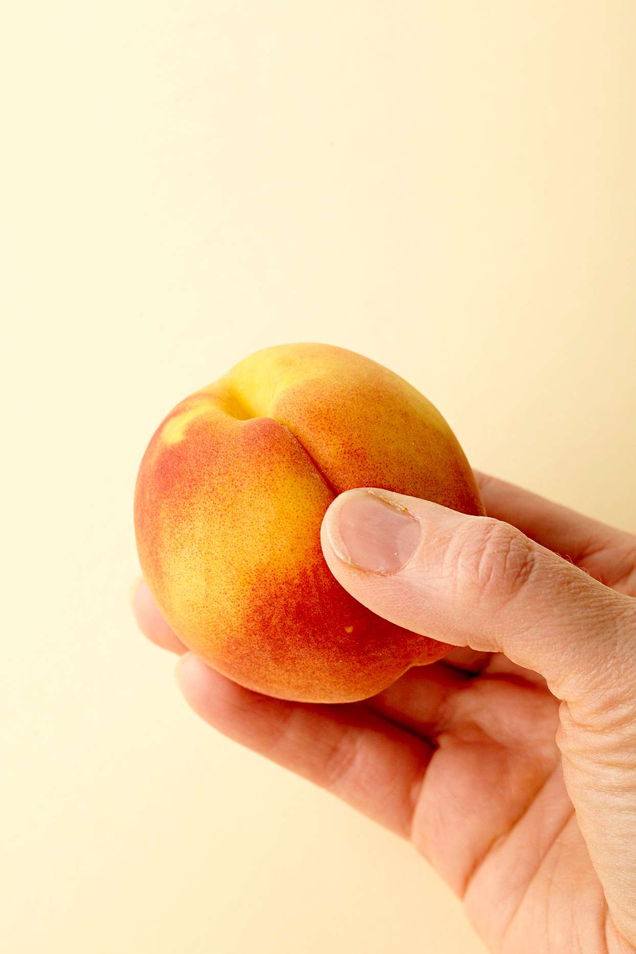 person holding a peach