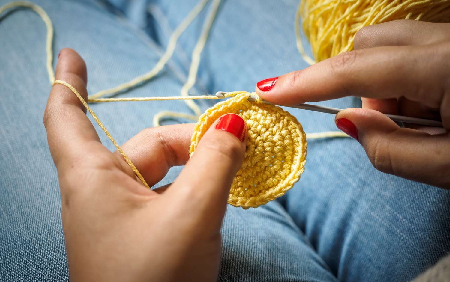 woman crocheting with yellow yarn