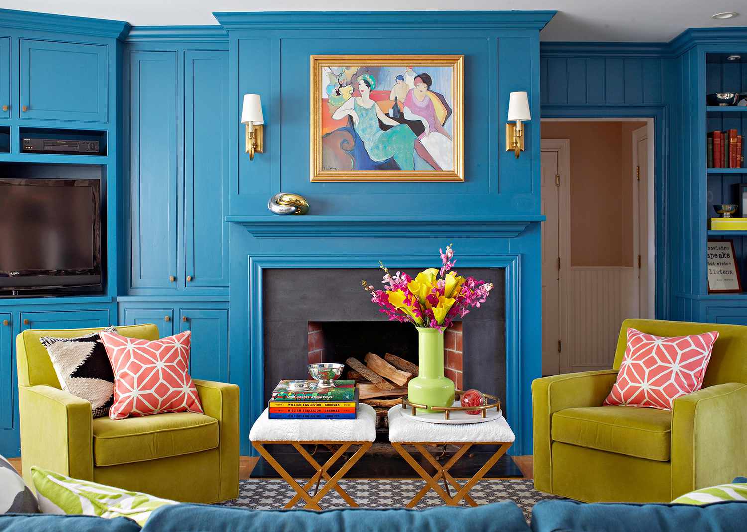 blue sitting room with green chairs and fireplace