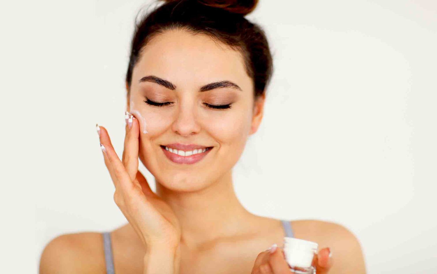 woman applying face lotion to her face