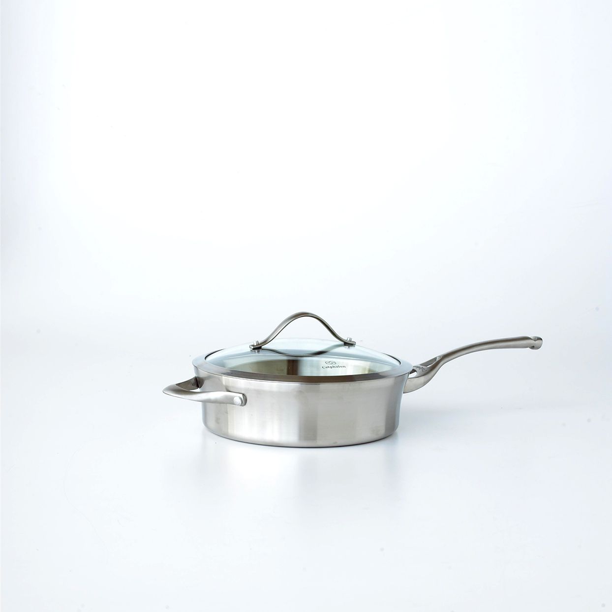 Empty 12-inch saut&eacute; pan with clear glass lid sitting on white surface.