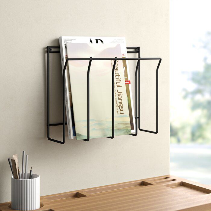 black wire magazine rack mounted to the wall