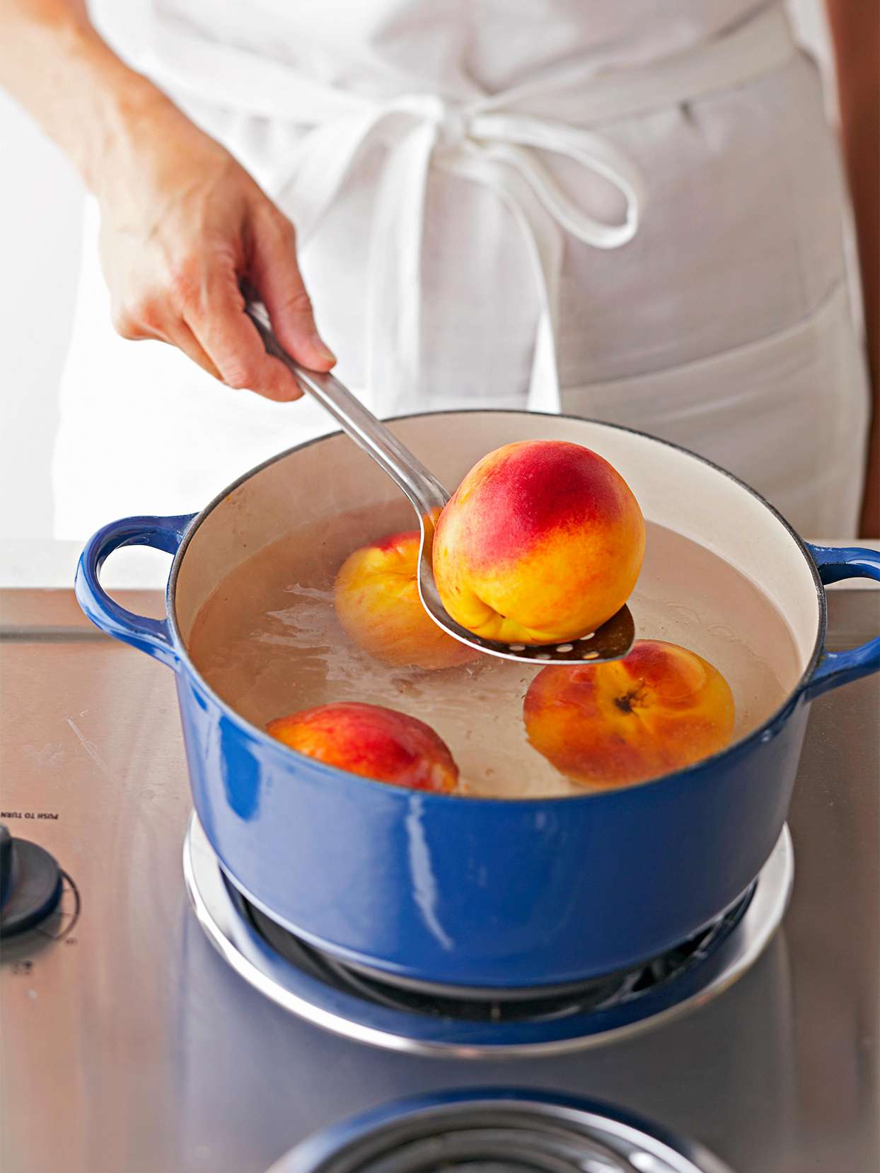 Blanching peaches in blue pot