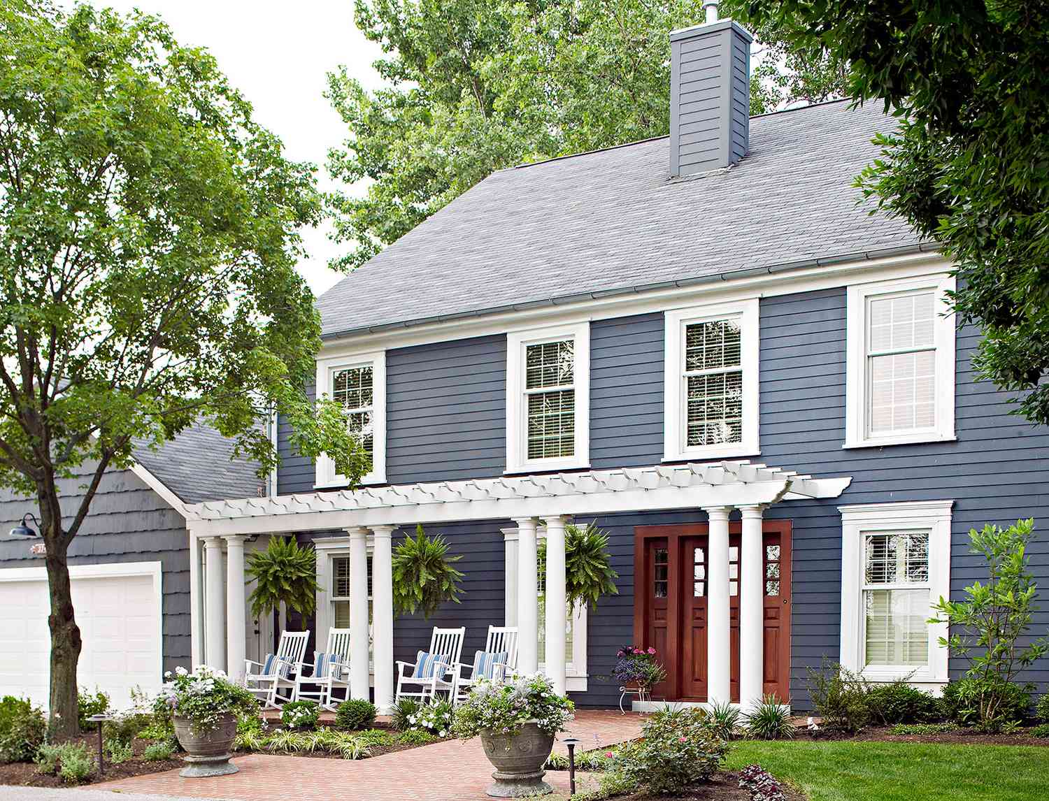 blue-gray home exterior with large arbor and engineered wood siding