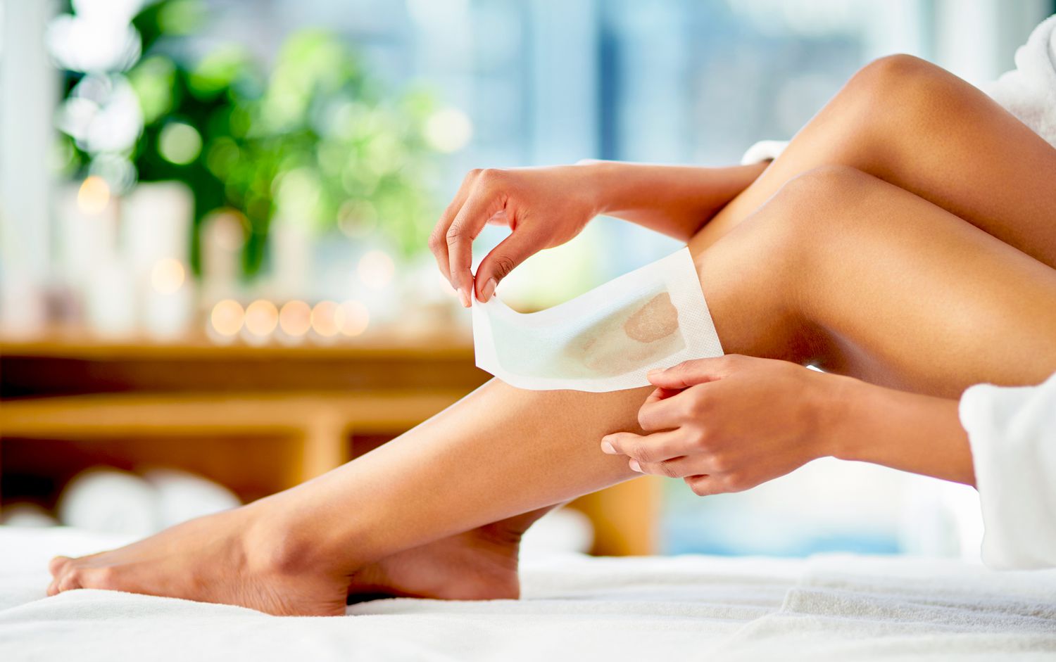 woman waxing her legs at home