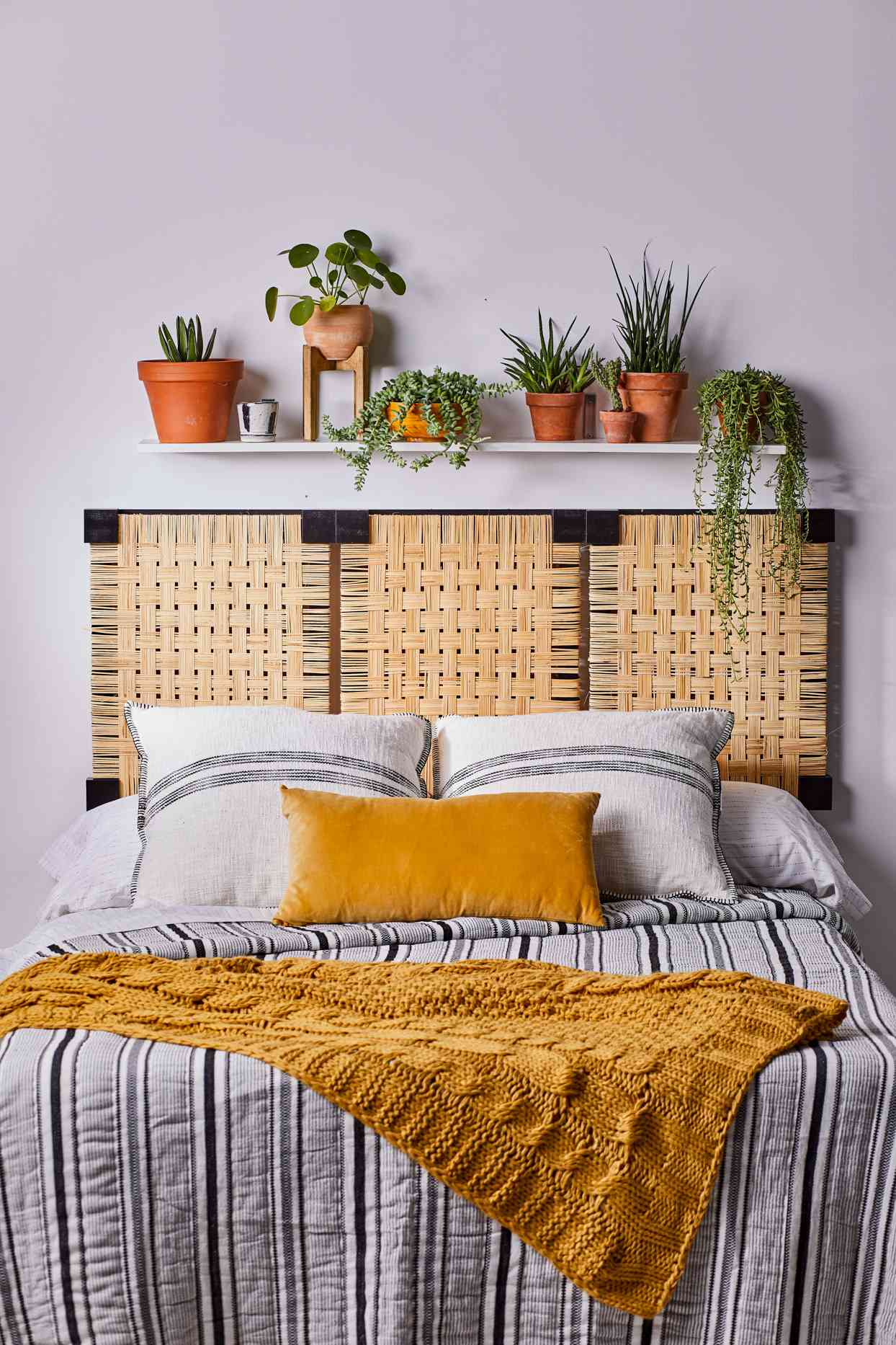 bedroom with striped bed spread and caned headboard