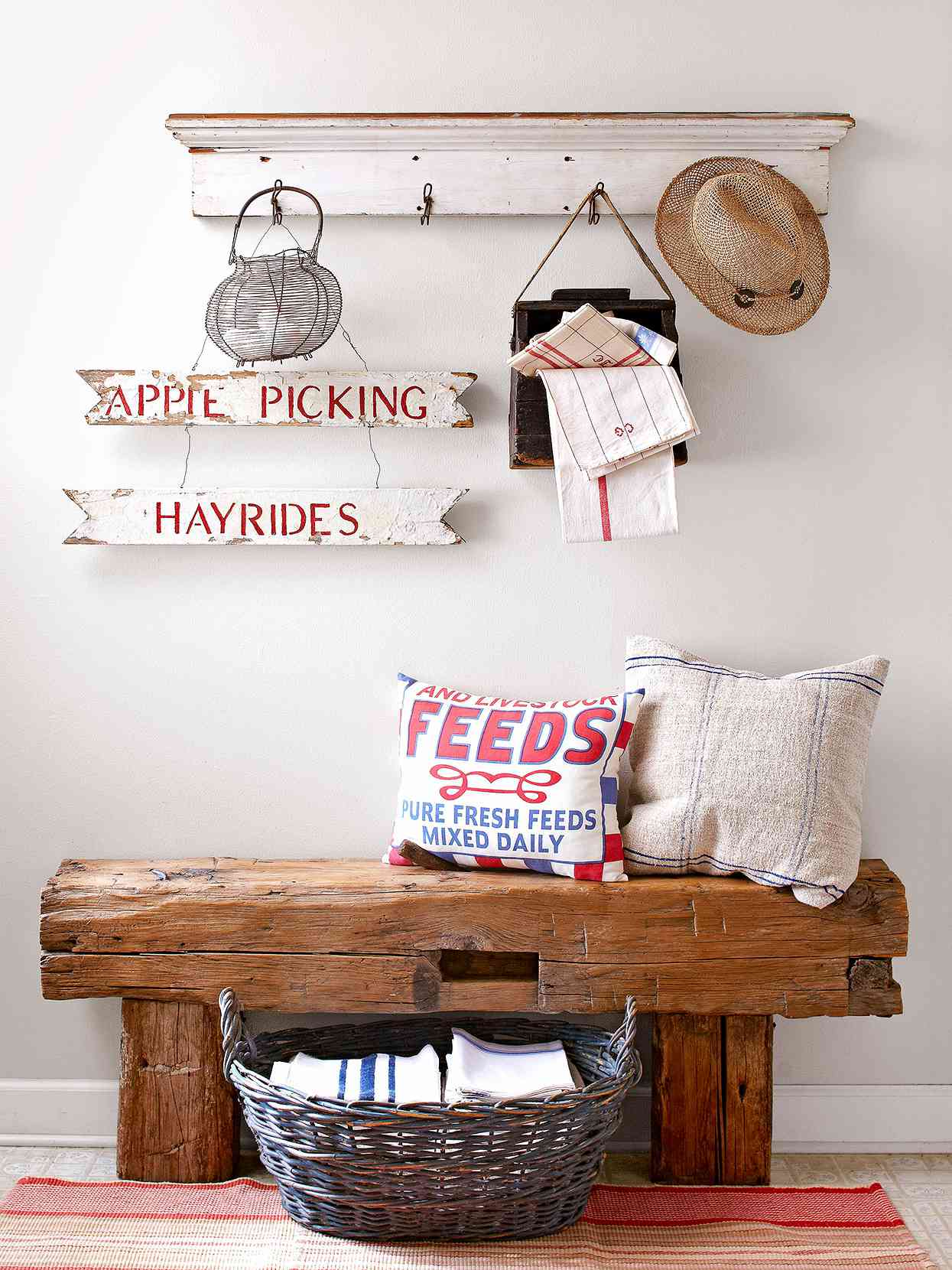 rustic bench with feed sack pillows above shelf with hooks