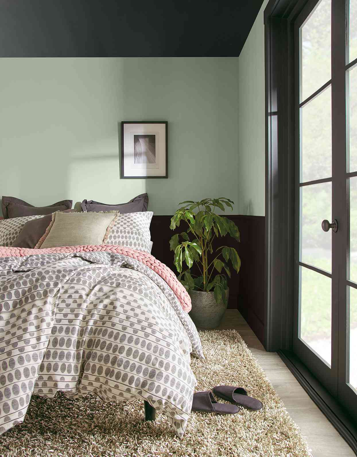 bedroom with light green walls and dark trim