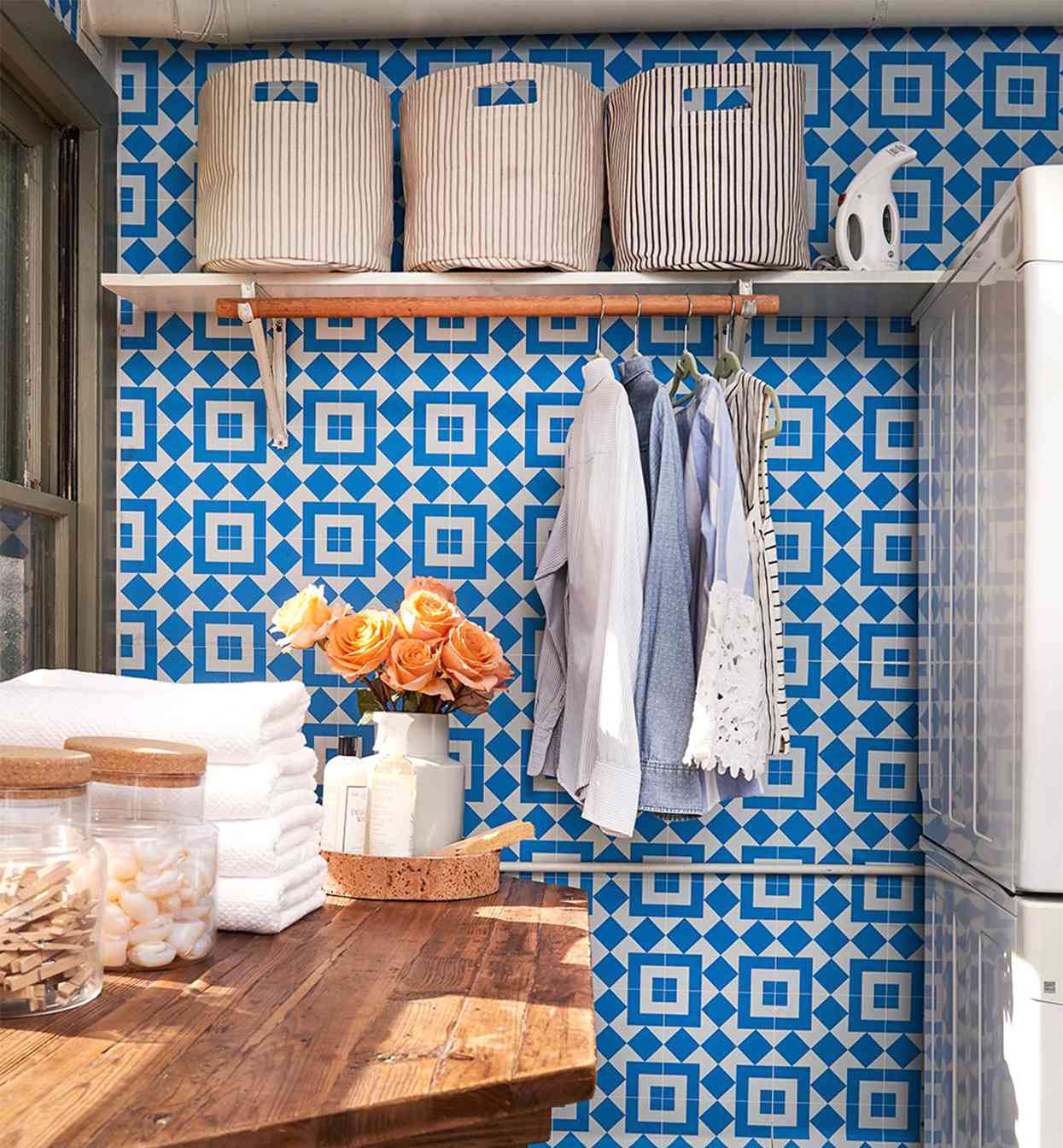 laundry room with blue geometric wallpaper and shelf