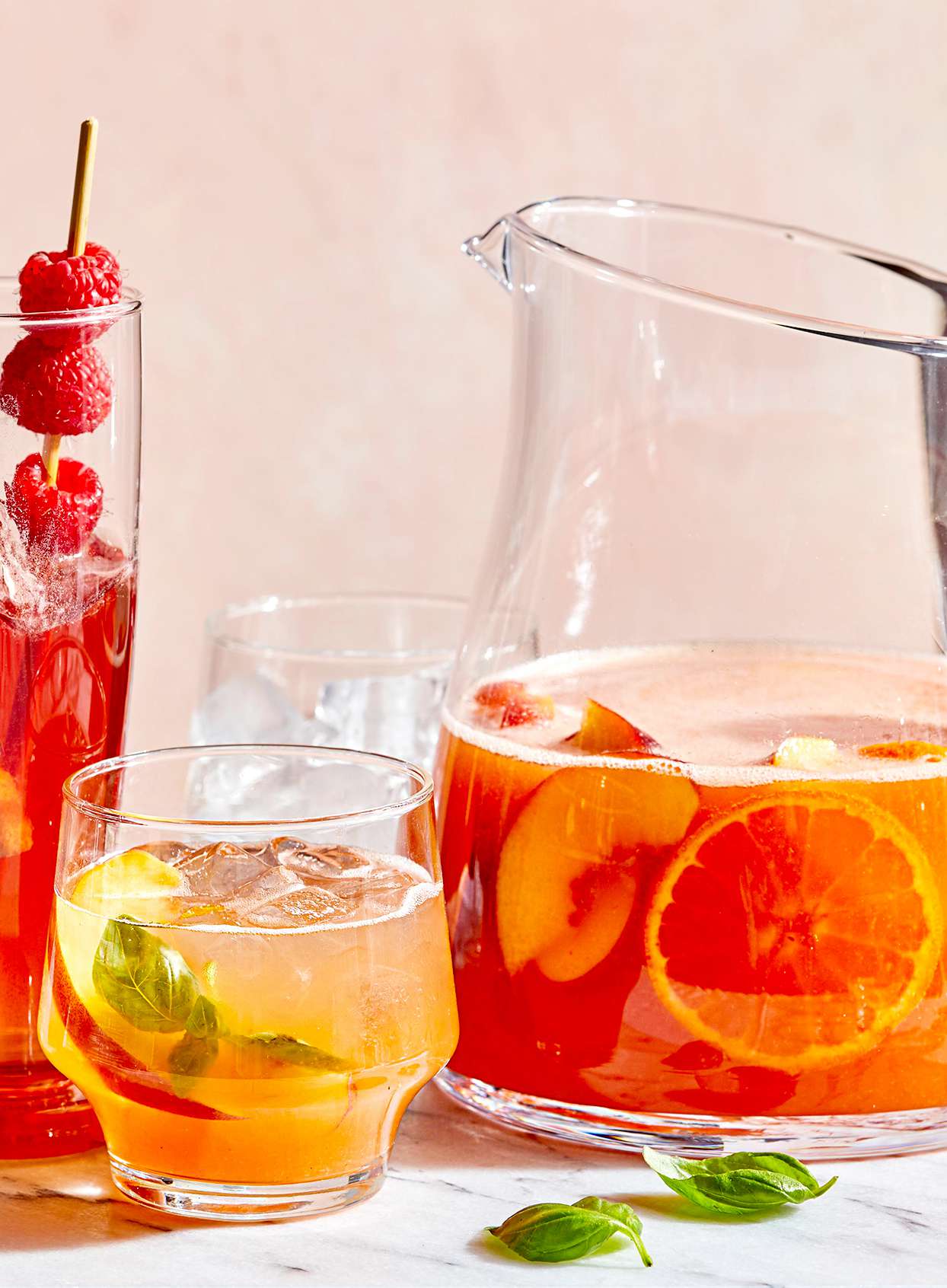 Peach Aperol Punch in short glass with pitcher