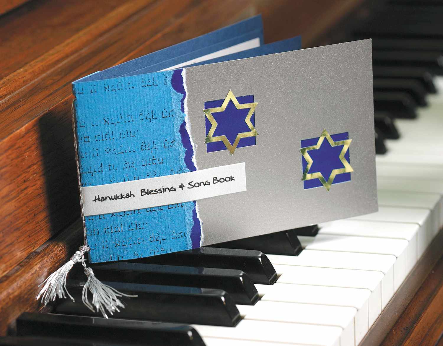 DIY Hanukkah blessing and songbook atop piano keys