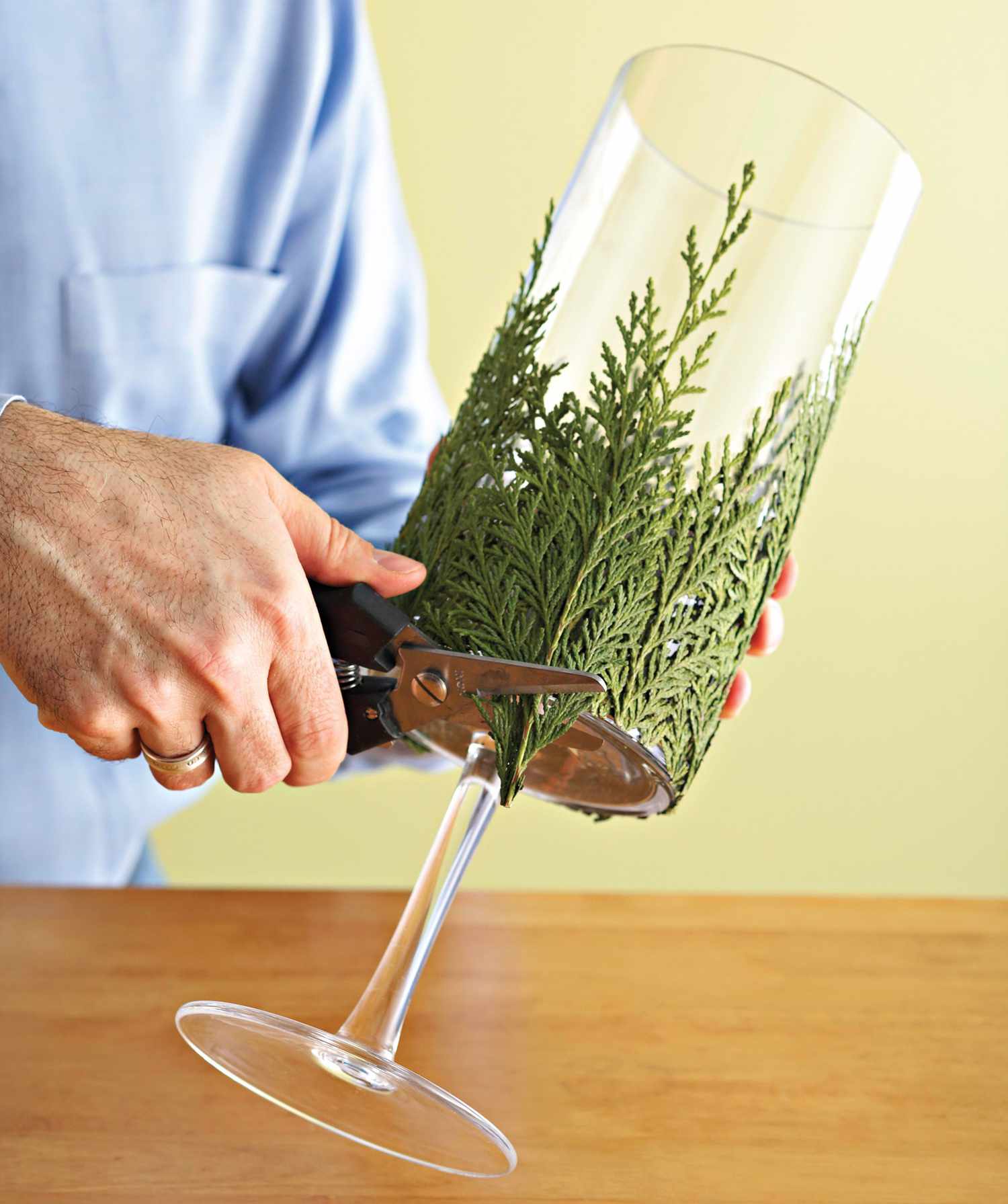 trimming evergreen around bottom of candle holder
