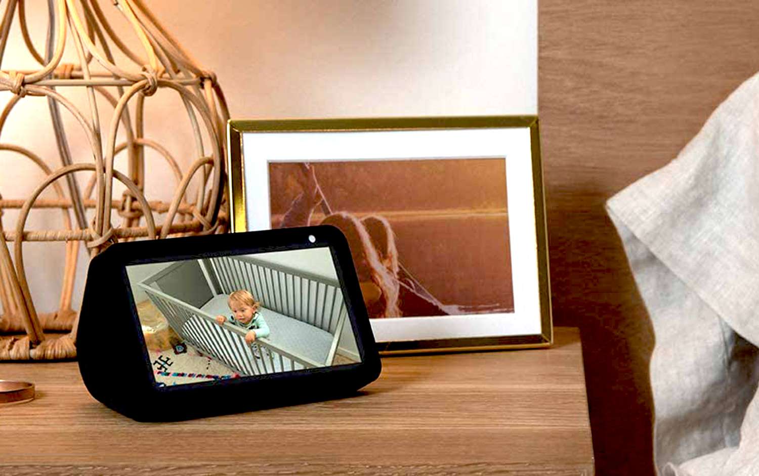 An Echo Show 5 on a bedside table in a bedroom