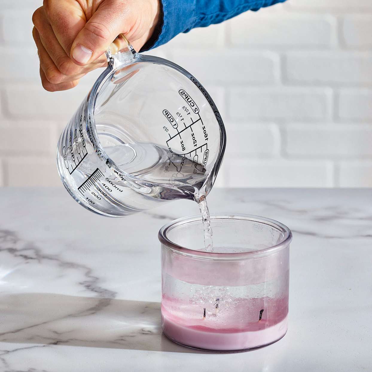 pouring water into candle jar