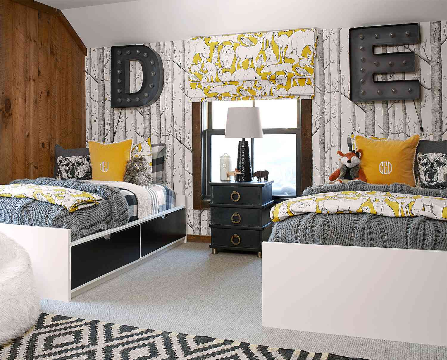 twin storage beds in kids bedroom with tree wallpaper, letter marquis decor and yellow accents