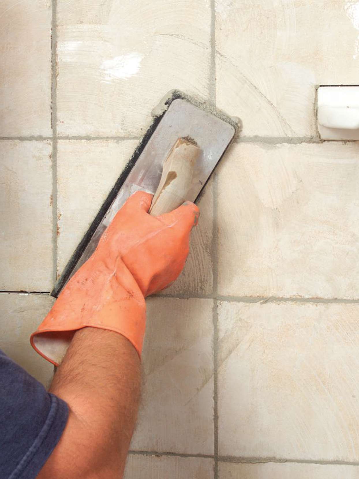 applying grout to tiled shower walls