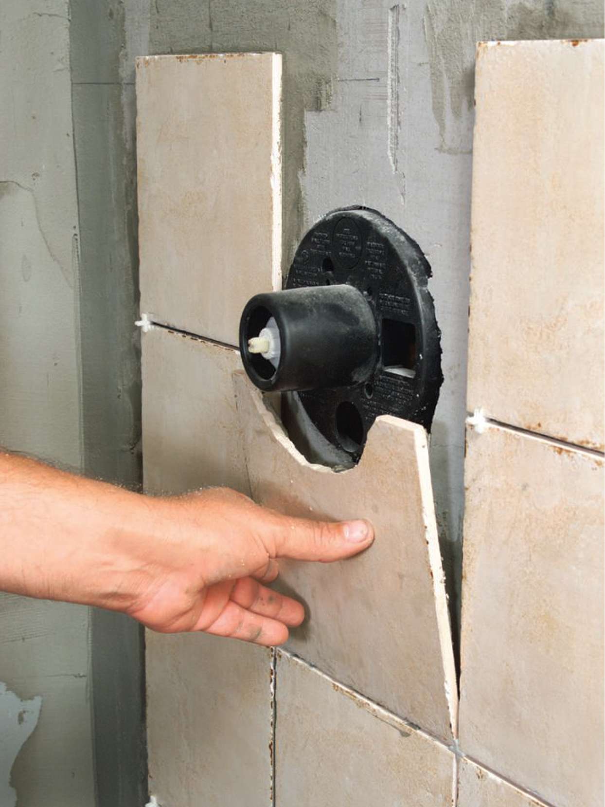 installing tiles around shower fixtures