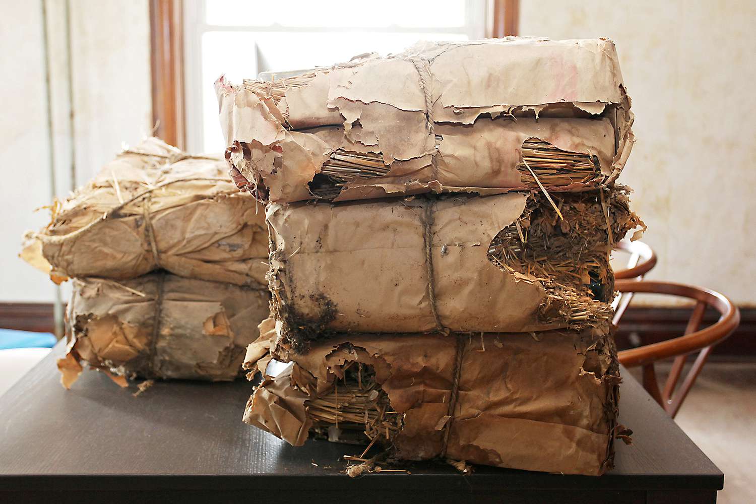 stacked paper-wrapped bundles of prohibition-era imported whiskey bottles