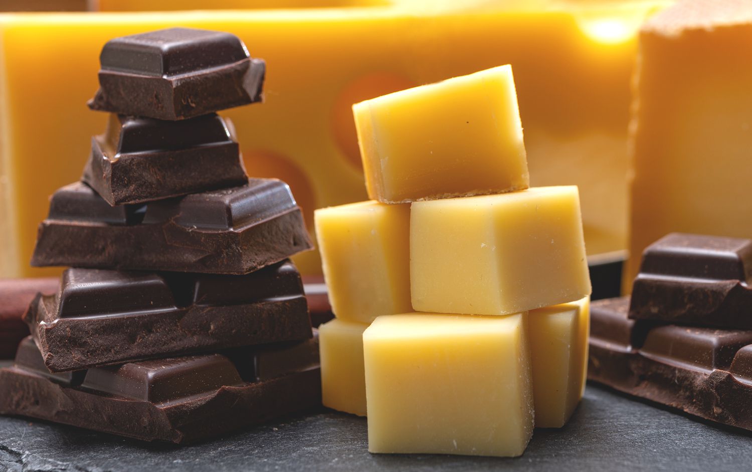 stacks of chocolate and cheese on a slate surface