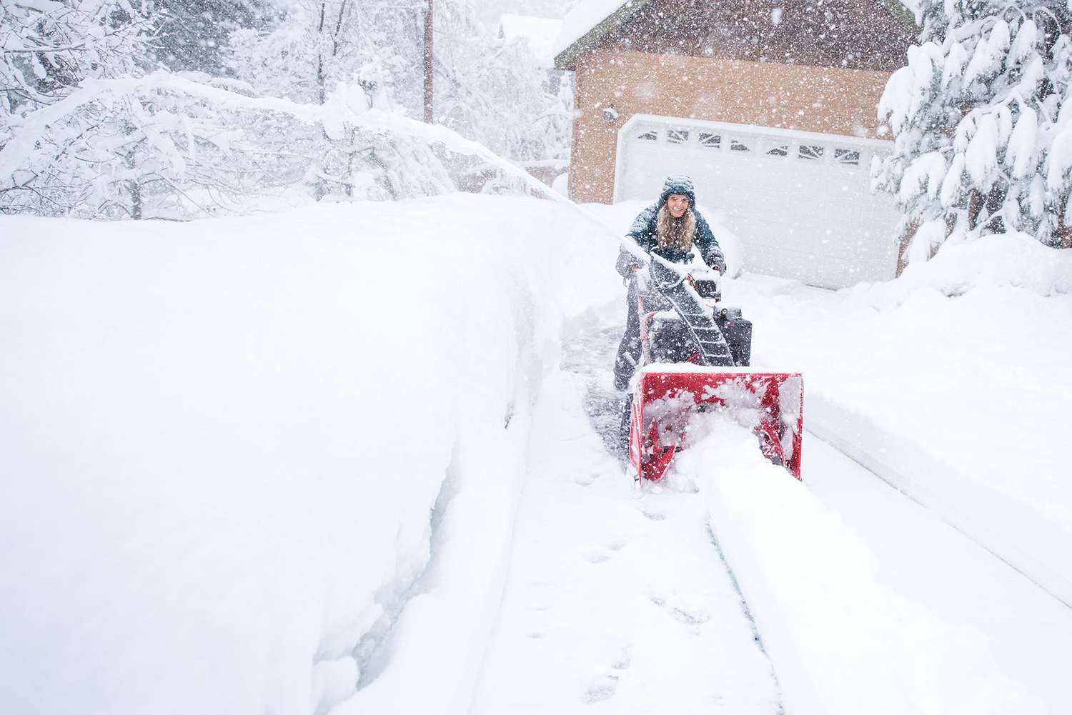 woman snowblowing driveway
