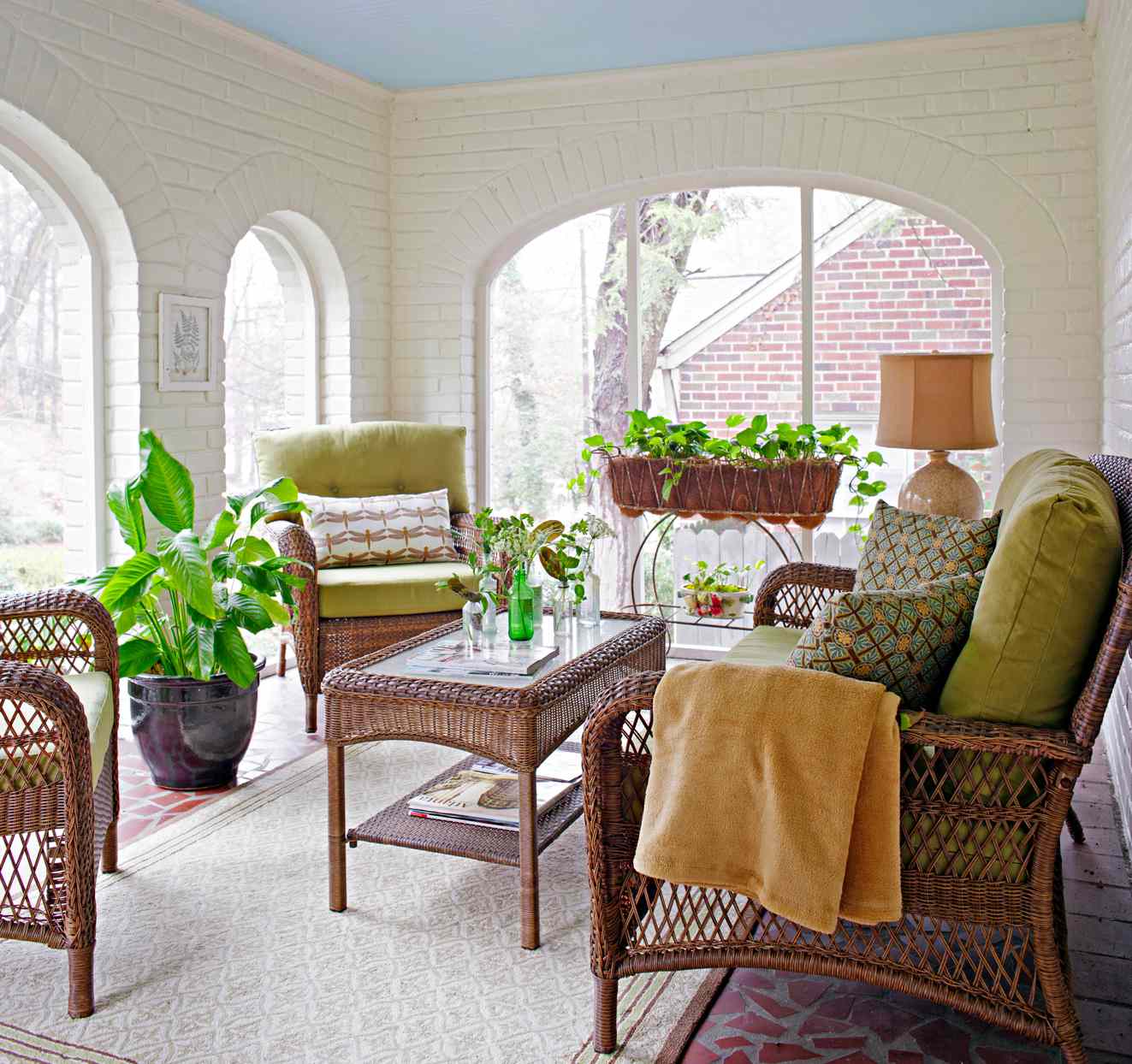 white painted brick porch with wicker furniture