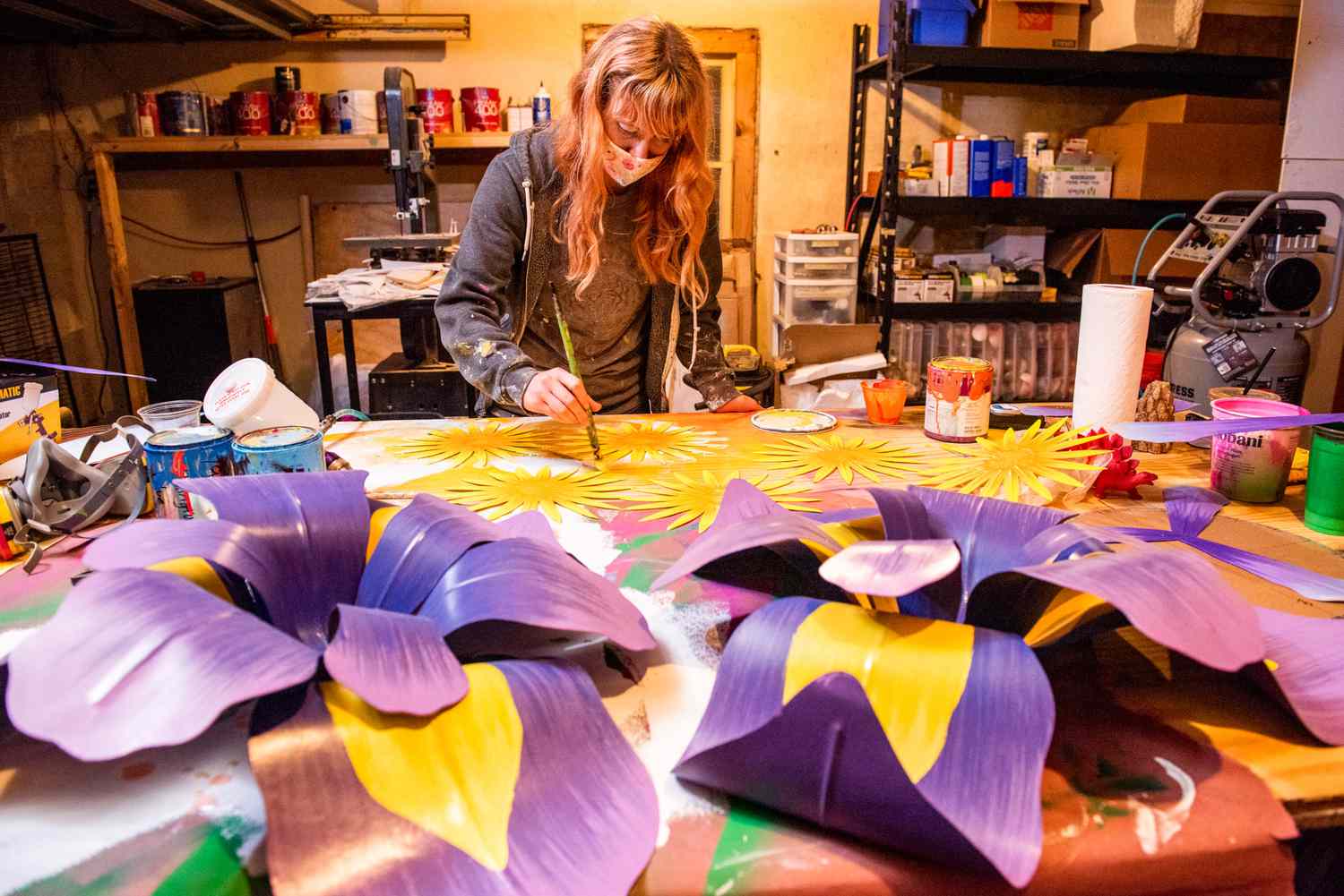 woman painting mardi gras flowers on table