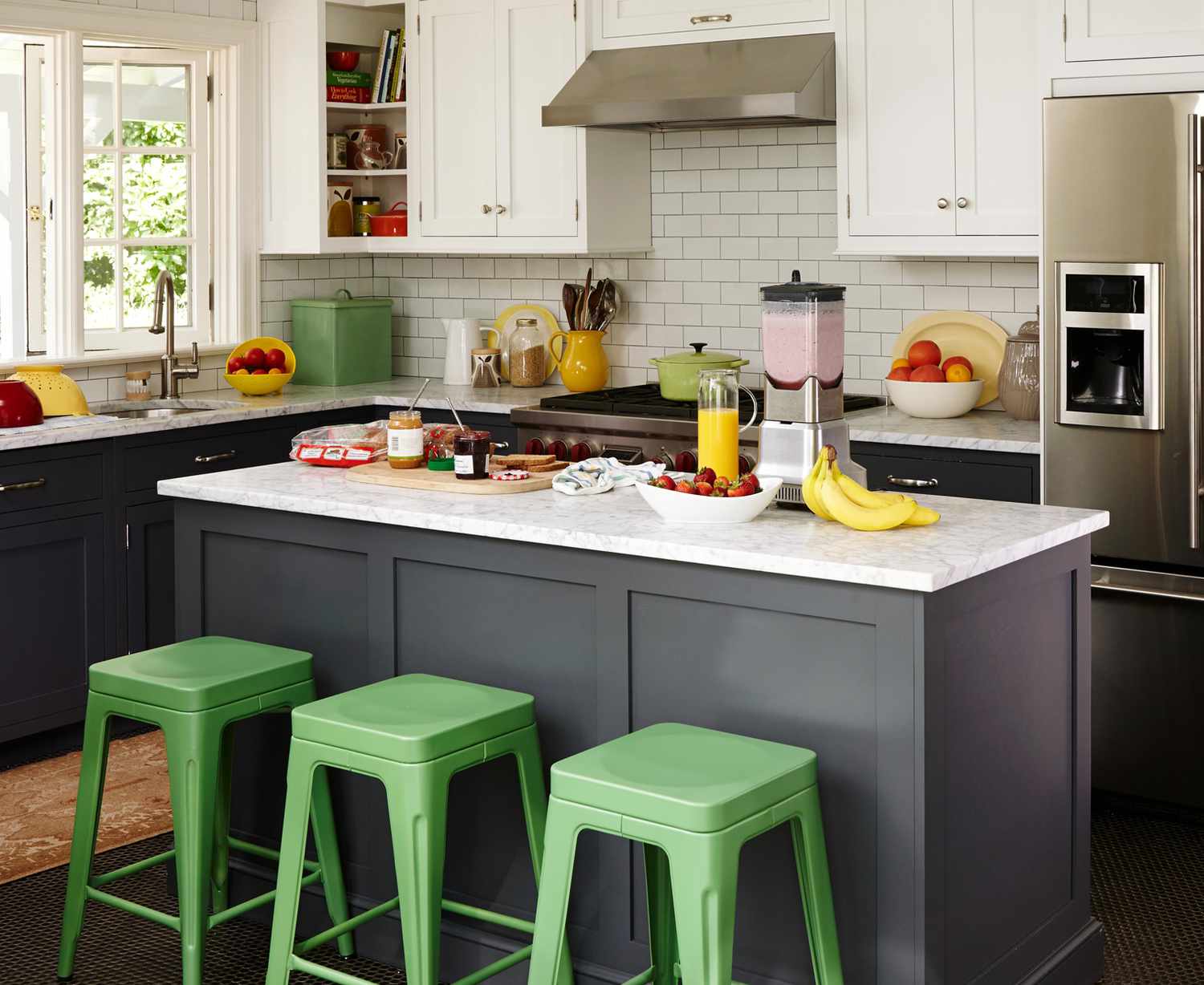 dark gray kitchen with subway tile backsplash and green stools