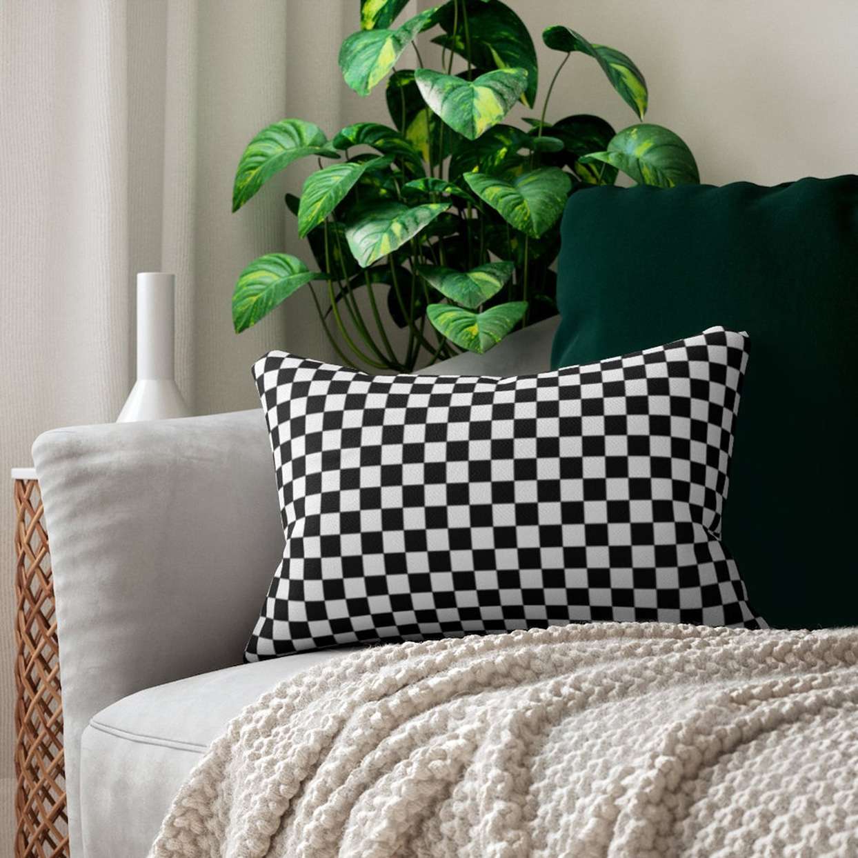 black and white checkerboard pillow on sofa with white knit throw