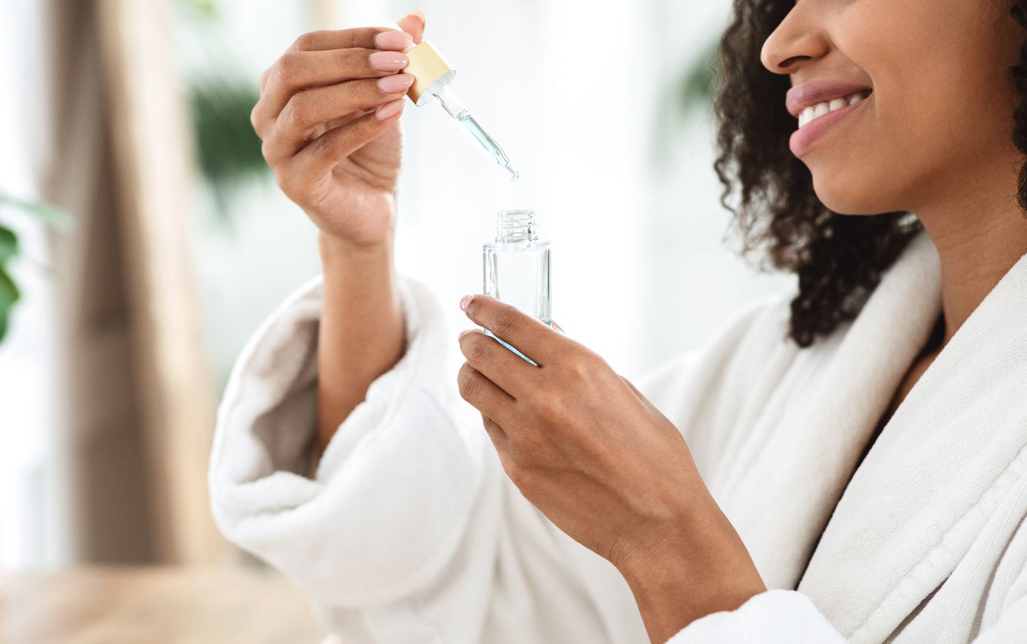 African American woman with serum vial in white robe