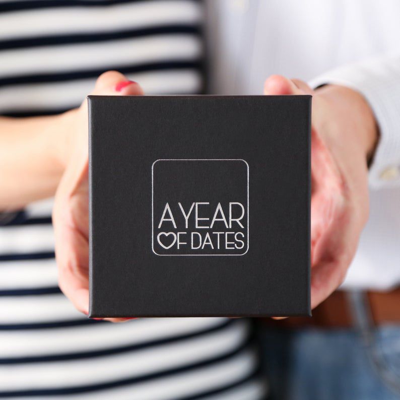 hands holding a black box that says a year of dates