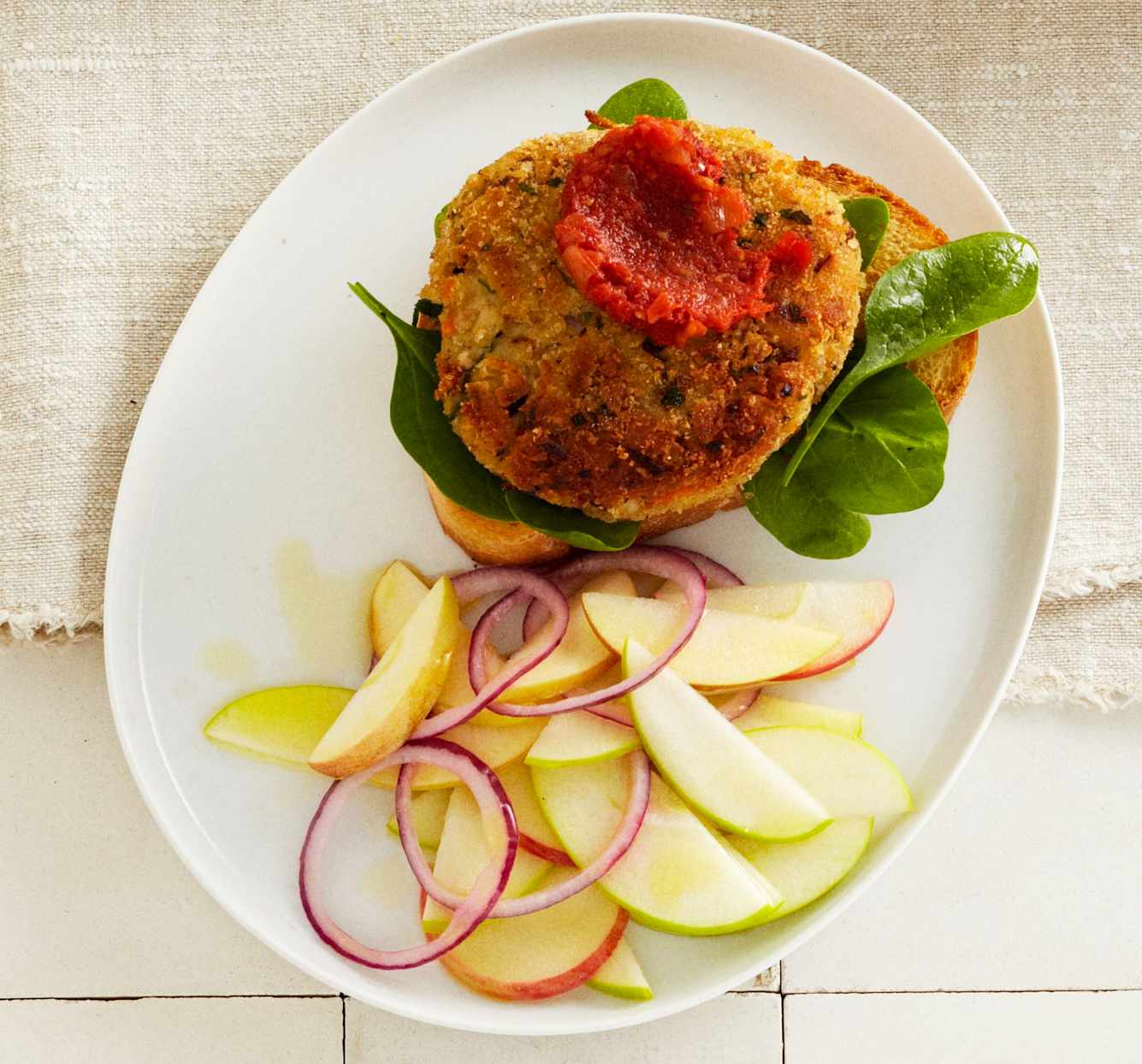 veggie burger with sliced apples and onions