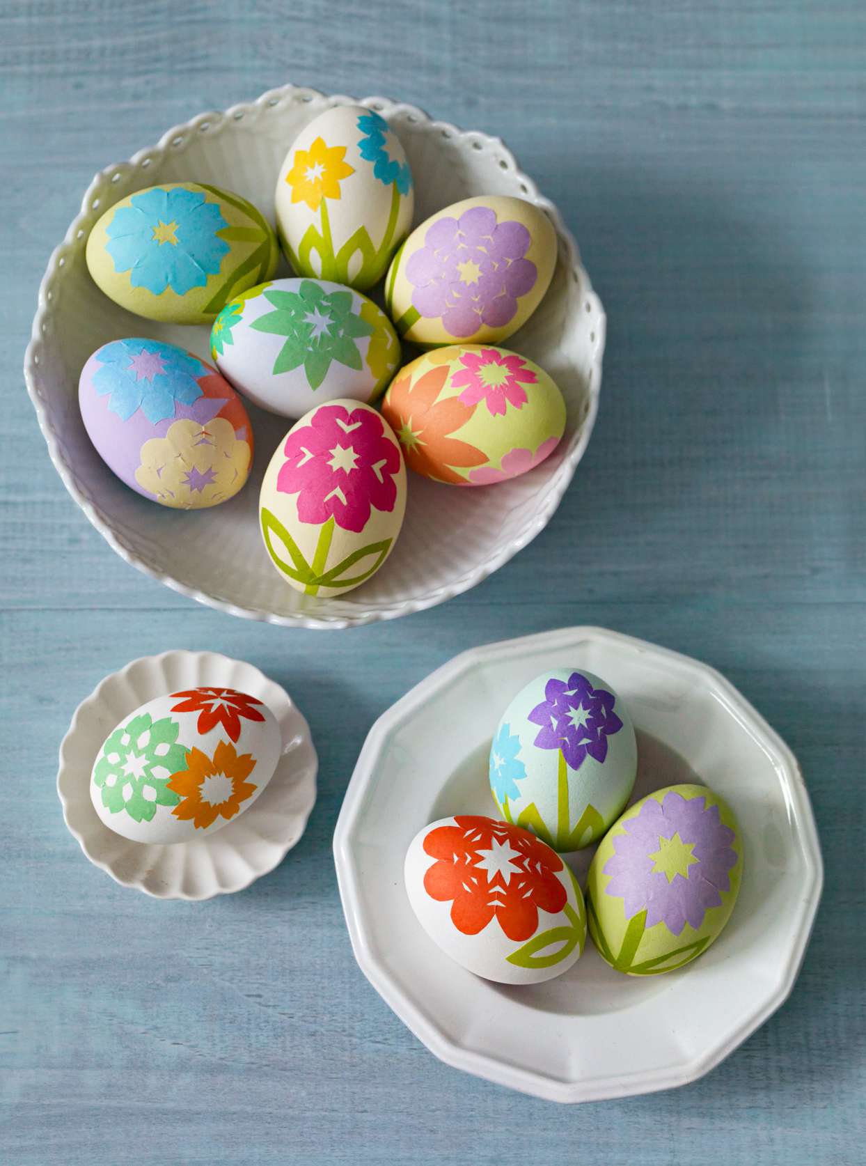 paper flowers on eggs in 3 white bowls