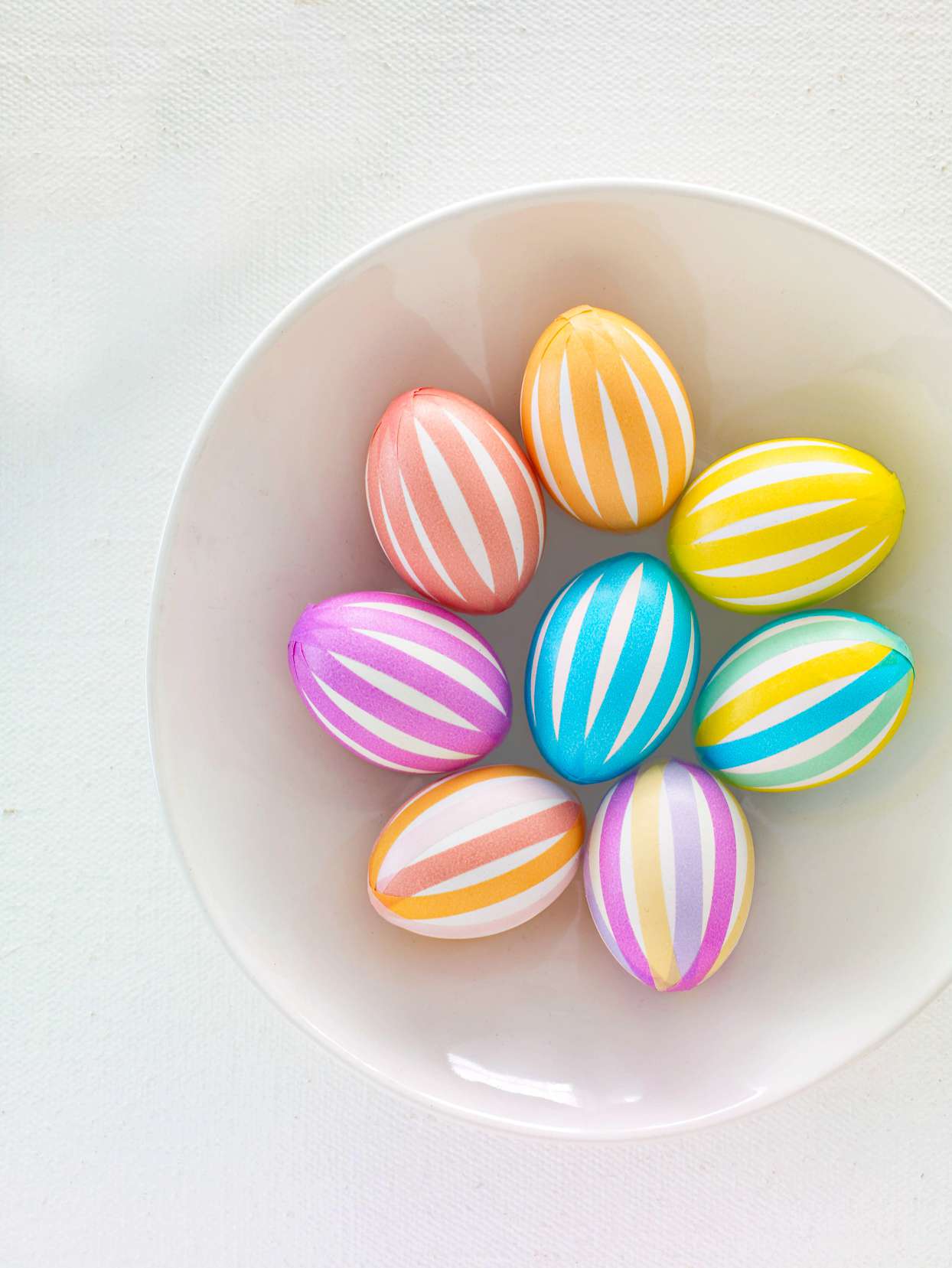 pastel striped easter eggs in white bowl