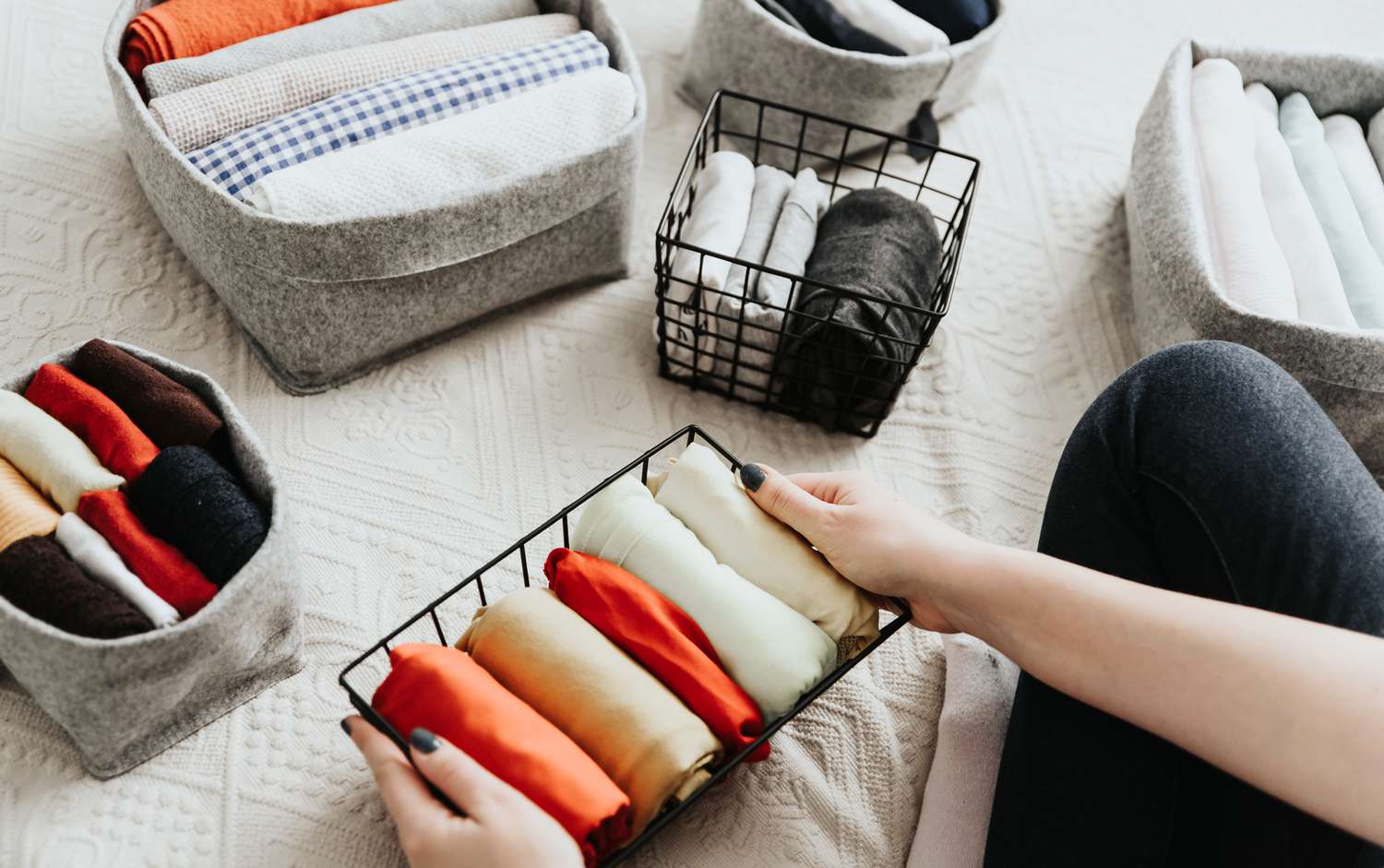Woman organizing her clothes into baskets