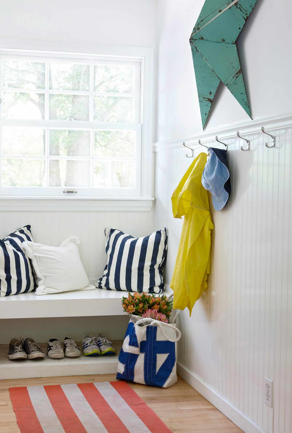 white mudroom bench with pillows shoe storage below