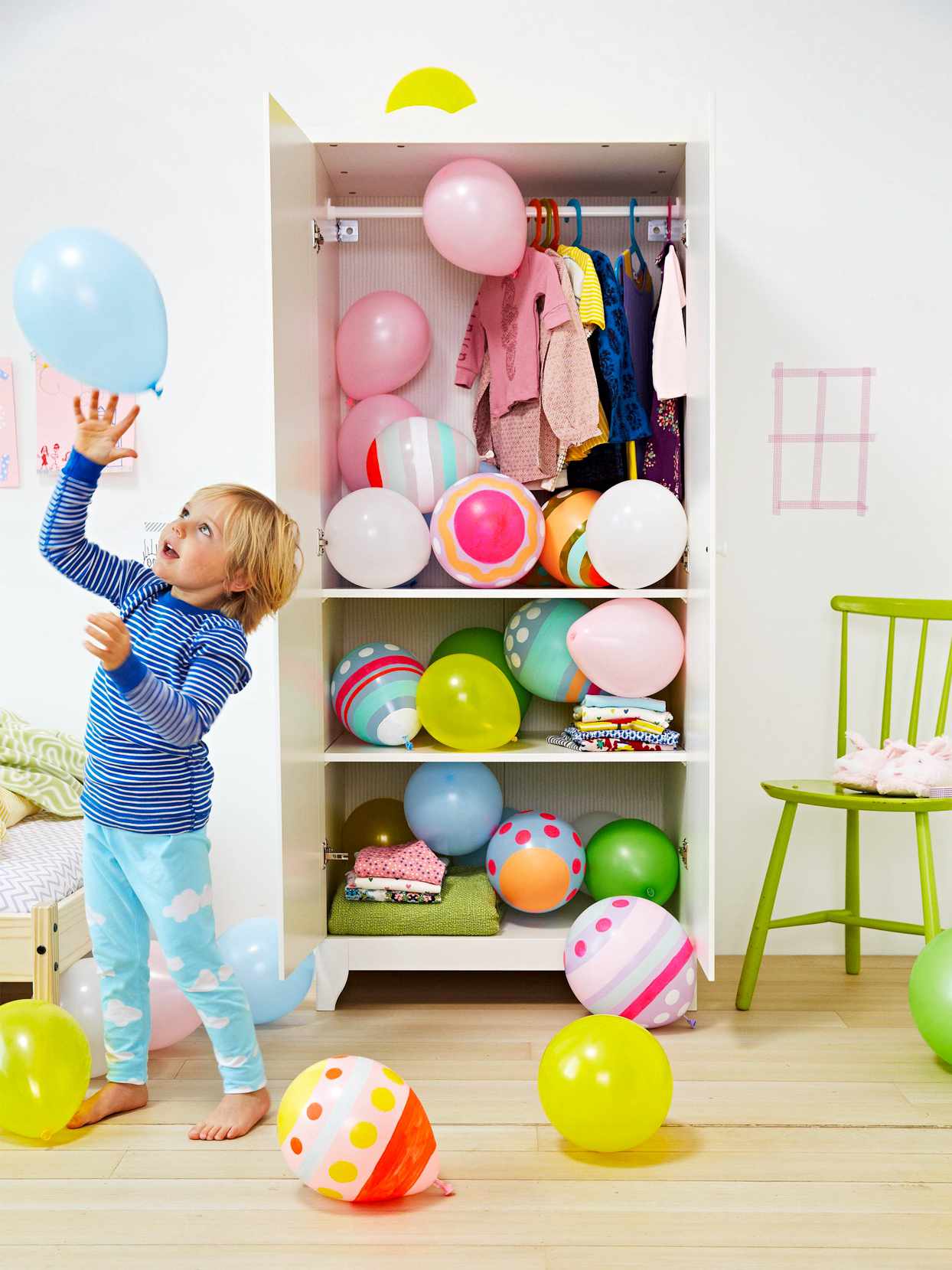 child playing with easter egg decorated balloons