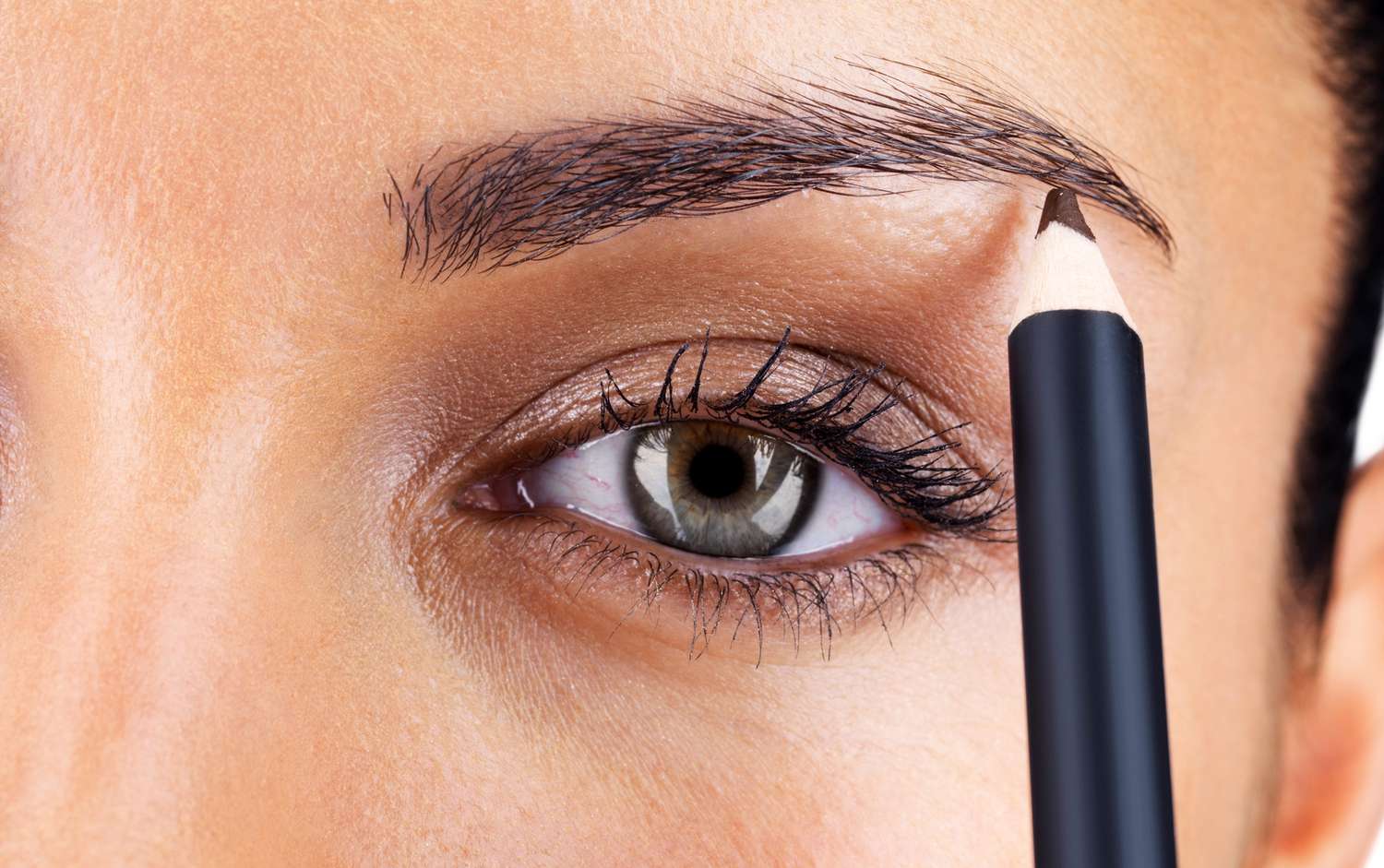 close up of a woman using an eyebrow pencil