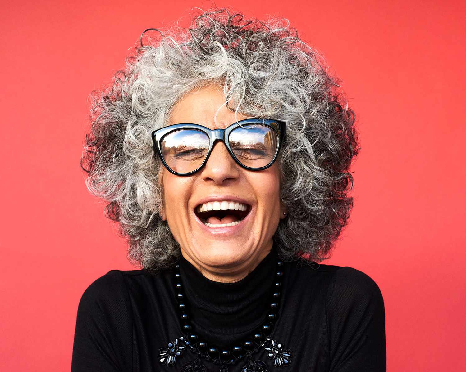 woman with gray hair and black glasses