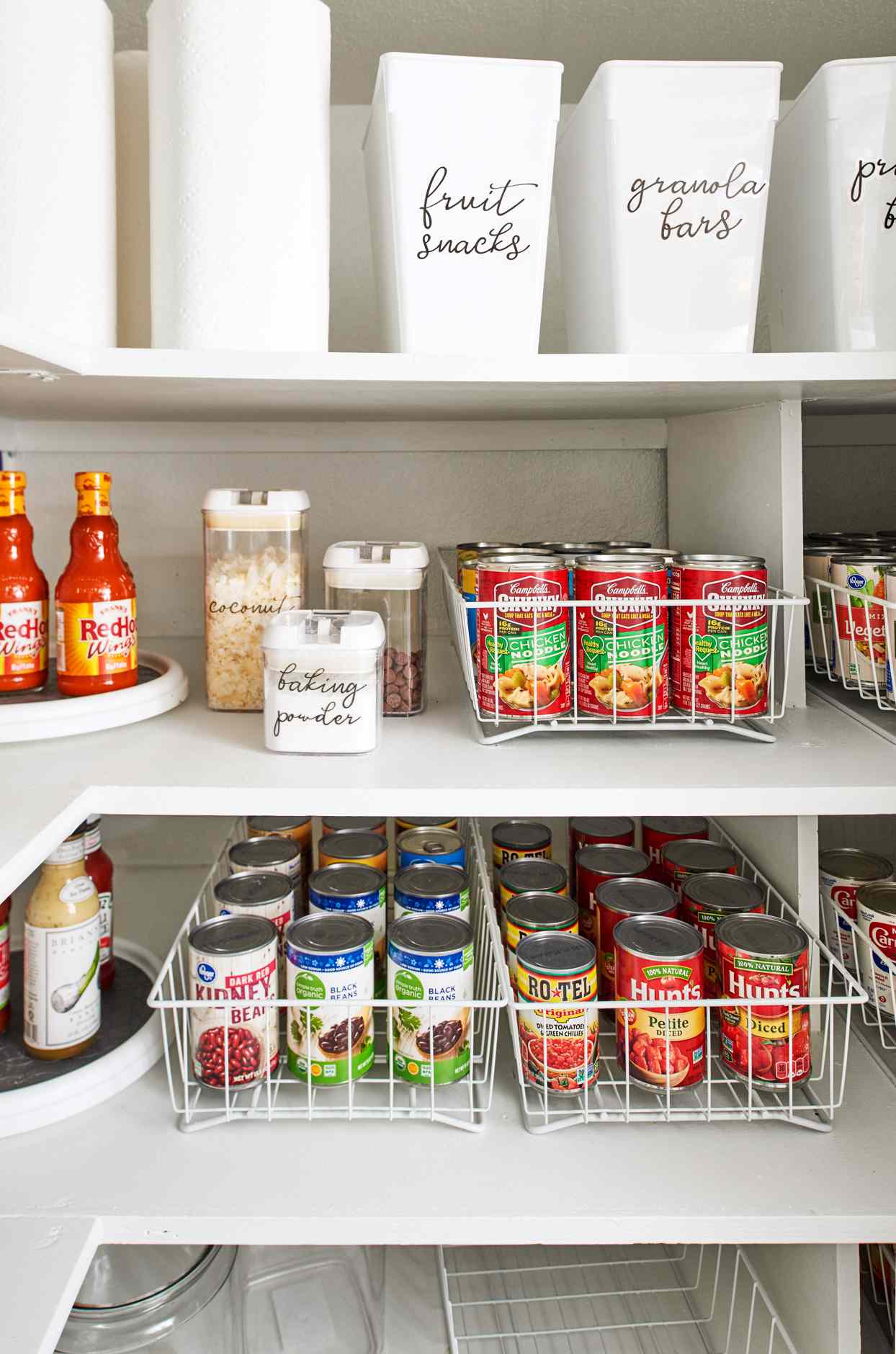 close up of cans in white wire racks in pantry