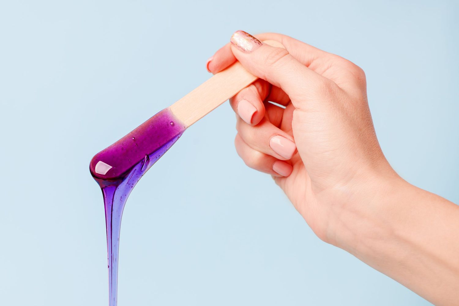 person holding wax stick with dripping wax