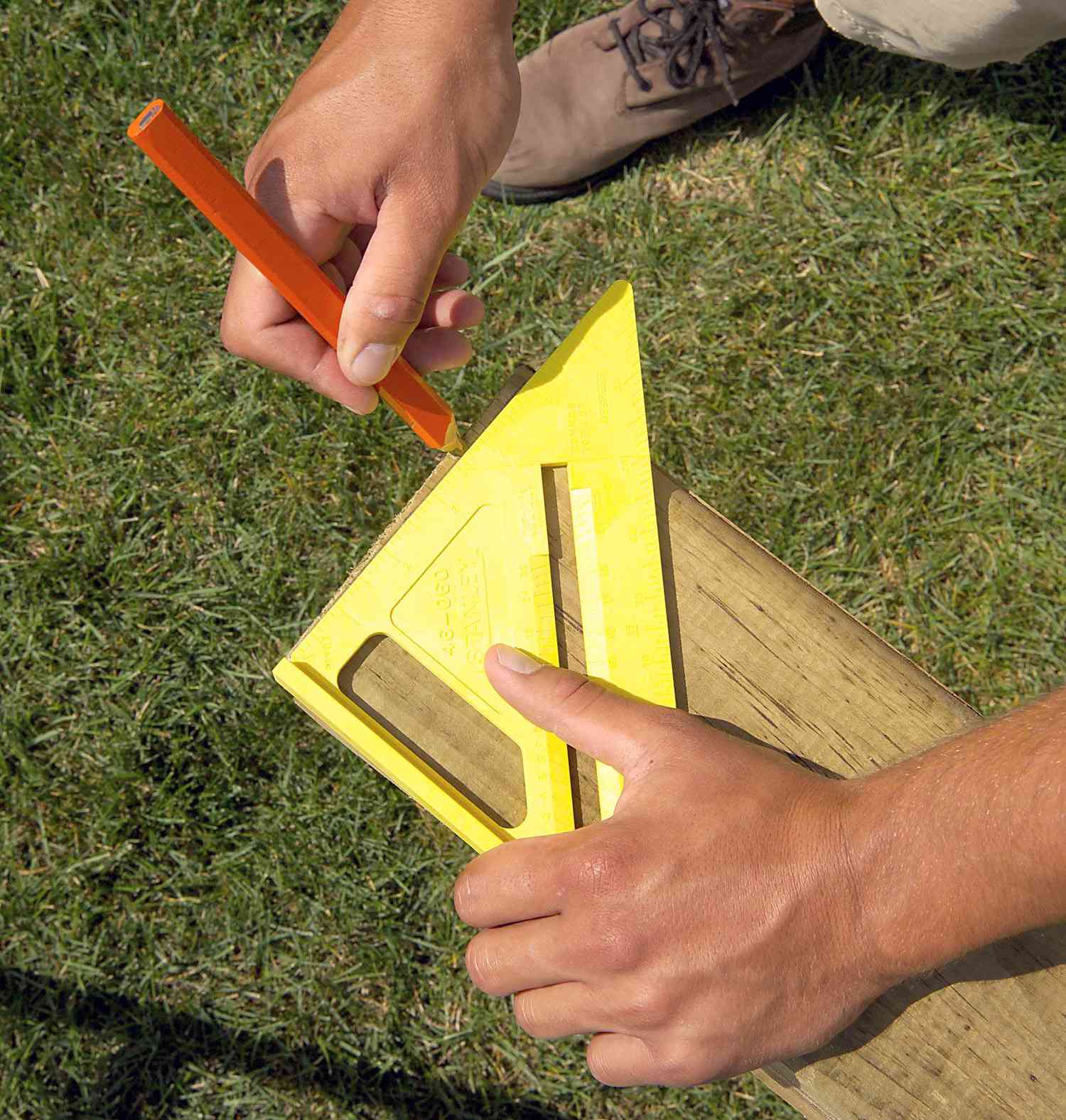 marking wood with pencil and yellow speed square