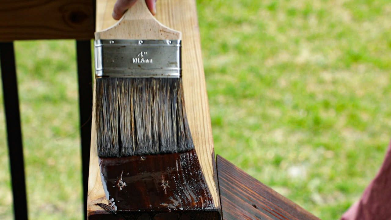 staining a deck with a paint brush