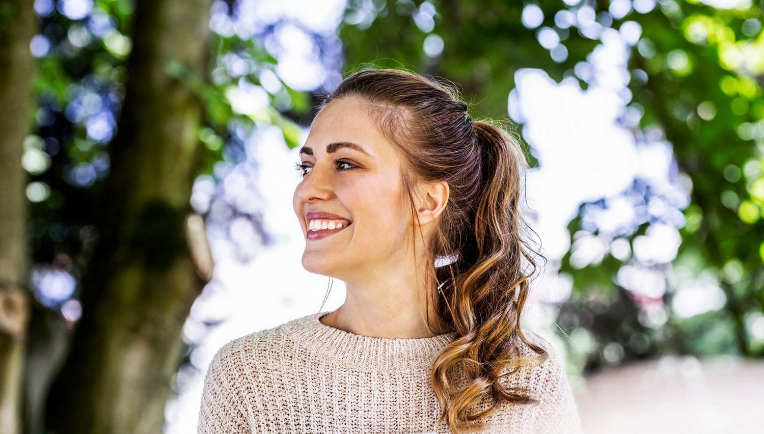 smiling woman in park with a high ponytail