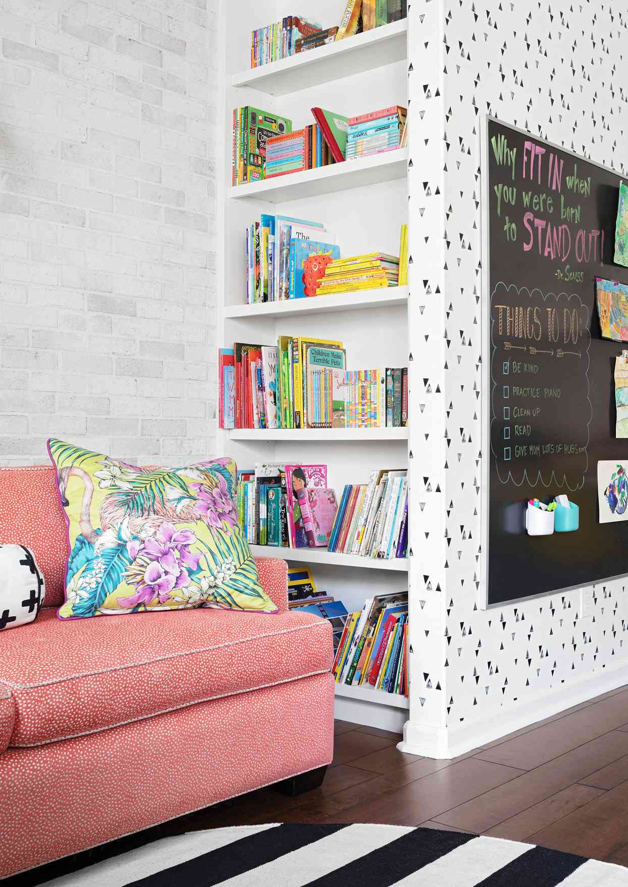 pink sofa floor-to-ceiling bookcase chalkboard pillow playroom
